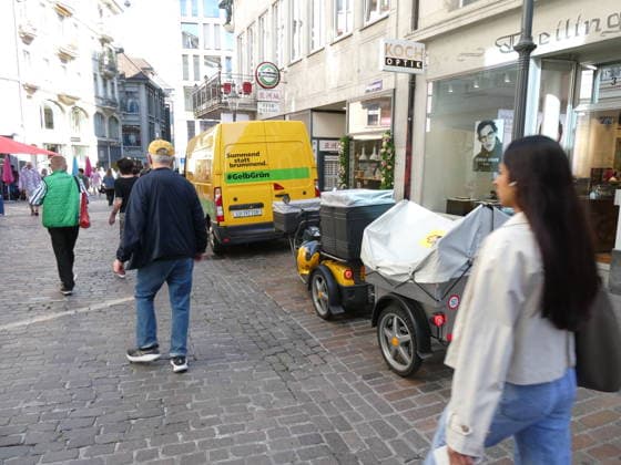 September 29, 2026, Switzerland: Photo of mail delivery using 100 percent electric delivery vans and an electric three-wheeled scooter