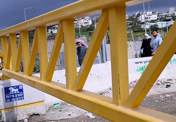 Palestinians walk past an Israeli erected locked gate that blocks cars from moving to and from the village of Khirt Zaytaba, near Hebron in the West Bank, on Tuesday, September 29, 2026. Israel declared a West Bank military closure to restrict Palestinian movement during the Jewish holiday of Sukkot from September 27 - October 3, 2026.  JER2026092907 DEBBIExHILL