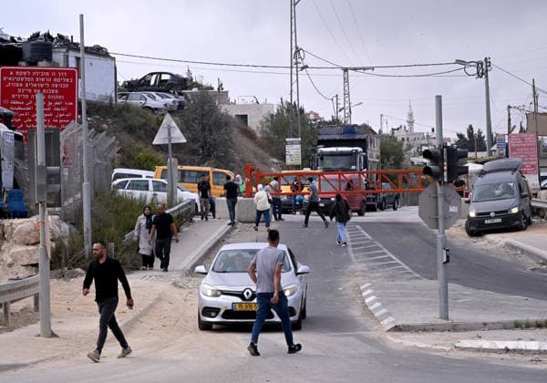Palestinians walk past an Israeli erected locked gate that blocks cars from moving to and from the village of Halhul, near Hebron in the West Bank, on Tuesday, September 29, 2026. Israel declared a West Bank military closure to restrict Palestinian movement during the Jewish holiday of Sukkot from September 27 - October 3, 2026.  JER2026092909 DEBBIExHILL