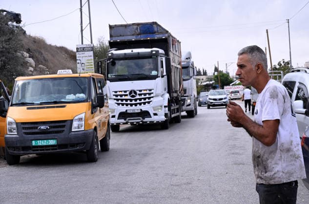 A Palestinian smokes near traffic stopped by an Israeli erected locked gate that blocks cars from moving to and from the village of Sair, near Hebron in the West Bank, on Tuesday, September 29, 2026. Israel declared a West Bank military closure to restrict Palestinian movement during the Jewish holiday of Sukkot from September 27 - October 3, 2026.  JER2026092903 DEBBIExHILL