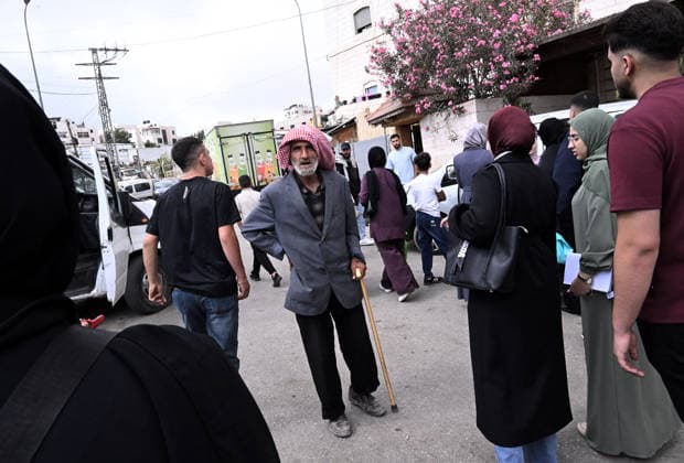 Palestinians wait behind an Israeli erected locked gate that blocks cars from moving to and from the village of Khirbat Zayta, near Hebron in the West Bank, on Tuesday, September 29, 2026. Israel declared a West Bank military closure to restrict Palestinian movement during the Jewish holiday of Sukkot from September 27 - October 3, 2026.  JER2026092913 DEBBIExHILL