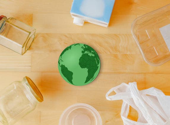 Recycling Concept with a Greens Globe, surrounded from Glasses, a Plastic bag, Plastic containers and a Milk carton at a Wooden table, Top view, Sustainability and Waste separation 1135900967