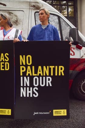 September 30, 2026, London, England, United Kingdom: Healthcare professionals stand with placards next to a van made to look like a heavily damaged Gaza ambulance as Amnesty International UK and Just Treatment stage a protest outside Palantir headquarters in Soho Square. The campaigners are calling on the UK Government not to extend its NHS contract with the US tech company. London United Kingdom - ZUMAv130 20260930_zip_v130_009 Copyright: xVukxValcicx