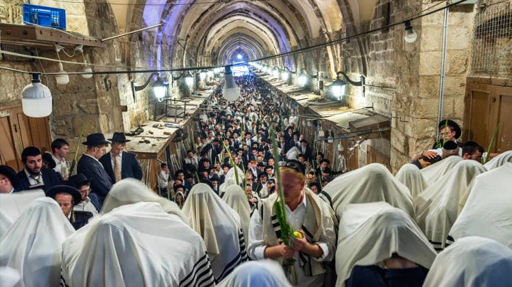 Religious Jews cover their heads with their prayers shawls as they perform morning prayers during the Holy Week of Sukkot, or the Feast of Tabernacles, in the Moslem Quarter in Jerusalem on Wednesday, September 30. 2026 Thousands of Jews, mostly ultra-Orthodox, packed a street leading to a gate, which was closed, leading into the Temple Mount or the á¸¤aram al Sharif where the Al Aqsa Mosque is located.  JER20260930003 JimxHollander
