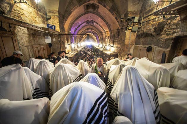 Religious Jews cover their heads with their prayers shawls as they perform morning prayers during the Holy Week of Sukkot, or the Feast of Tabernacles, in the Moslem Quarter in Jerusalem on Wednesday, September 30. 2026 Thousands of Jews, mostly ultra-Orthodox, packed a street leading to a gate, which was closed, leading into the Temple Mount or the á¸¤aram al Sharif where the Al Aqsa Mosque is located.  JER20260930007 JimxHollander