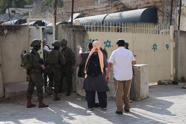 September 30, 2026, Hebron, Palestine, State of: HEBRON, OCCUPIED WEST BANK, SEPTEMBER 30, 2026: Israeli settlers walk through Hebron s Old City under the protection of Israeli forces during celebrations for the Jewish holiday of Sukkot. Israeli forces maintained heightened security measures and movement restrictions around the Old City and the Ibrahimi Mosque during the holiday period. Hebron Palestine, State of  - ZUMAq101 20260930_zna_q101_120 Copyright: xMosabxShawerx