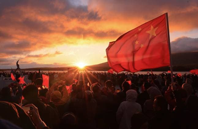 (261001) -- BEIJING, Oct. 1, 2026 -- People watch the sunrise in Fuyuan City, northeast China s Heilongjiang Province, Oct. 1, 2026. People celebrated the 77th anniversary of the founding of the People s Republic of China in various ways on Thursday. (Photo by Xinhua) CHINA-NATIONAL DAY-CELEBRATION (CN) LixYongjun 