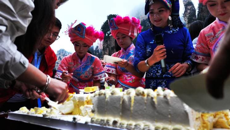 ZHANGJIAJIE, CHINA - OCTOBER 01: Tourists gather to celebrate the 77th anniversary of the founding of the People s Republic of China with folk activities including welcome drums, blocking-door wine, hand-waving dances, cake tasting and mountain songs at Bailong Elevator viewing platform in Zhangjiajie National Forest Park on October 1, 2026 in Zhangjiajie, Hunan Province of China.  Copyright: xVCGx 111670911302