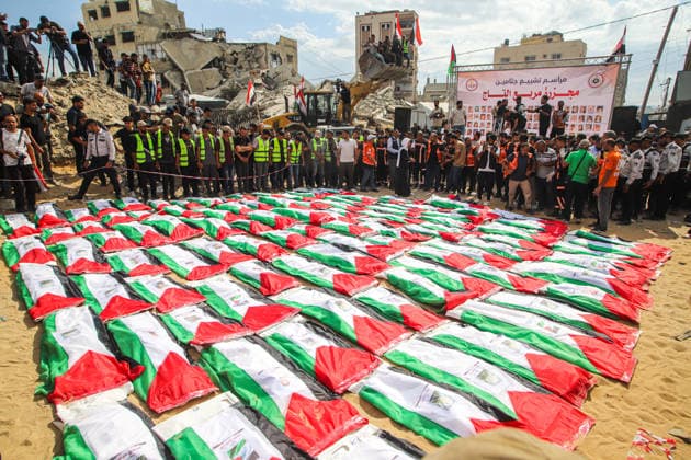 Gaza Mass Funeral For Victim Rows of Palestinian flag-draped shrouds fill an open area as a large crowd stands around them beside rubble and damaged buildings in Gaza City, Gaza Strip, on October 1, 2026. Gaza Civil Defense said the funeral was held for the remains of 105 people recovered from beneath the rubble of the Al-Taj residential complex and surrounding buildings in the Al-Yarmouk area, which were destroyed in Israeli strikes on October 25, 2023. The remains were taken for burial at Sheikh Radwan cemetery. Gaza Gaza Strip Palestinian Territories Copyright: xRamezxHabboubx