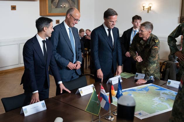 Visit to the German-Dutch Corps by Federal Chancellor Merz and Rob Jetten, Prime Minister of the Netherlands, together with Federal Chancellor Friedrich Merz, NATO Secretary General Mark Ruette listen intently to the remarks by Lieutenant General Peter Mirow, who is holding a map of Europe during a visit to the 1st German-Dutch Corps, Münster, October 1, 2026, Münste