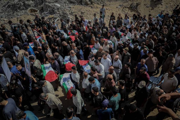 Gaza Funeral For Recovered Victims Mourners crowd around several Palestinian flag-draped shrouds as men begin lifting them from the ground during funeral proceedings in Gaza City, Gaza Strip, on October 1, 2026. Gaza Civil Defense said the remains were among those of 105 Palestinians recovered during a 17-day search of the Al-Taj residential block in the Al-Yarmouk area, which was struck by Israel on October 25, 2023. Gaza City Gaza Strip Palestinian Territories Copyright: xMohammedxMxSkaikx