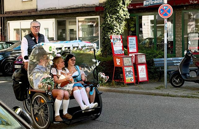 Oktoberfest in Munich Munich, Oktoberfest, October 26, 2011. A lively atmosphere during the final days of Oktoberfest, with glorious sunshine and temperatures over 20 degrees. Here, a rickshaw driver with festival-goers in traditional costumes. Munich, Theresienwiese, Bavaria, Germany