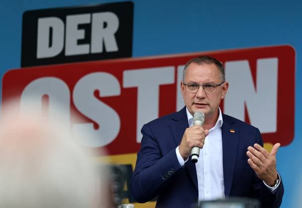 Enjoying a Bratwurst with Haseloff and Chrupalla, October 1, 2026, Doellstaedt, AfD event at Kiesling Roofing, Enjoying a bratwurst with State Parliament Representative Daniel Haseloff (AfD) and AfD National Spokesperson Tino Chrupalla; pictured: Tino Chrupalla giving a speech on stage, with the phrase The East is doing it visible in the background