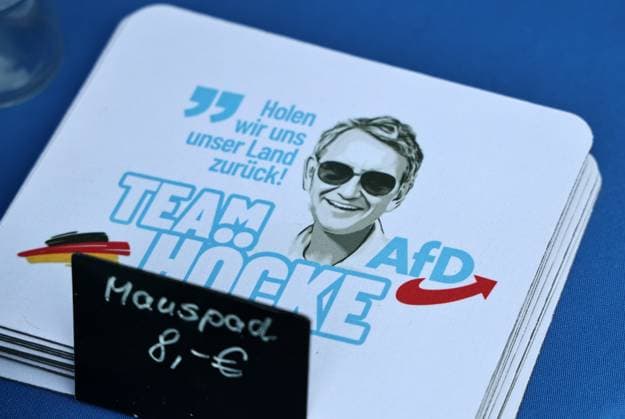 Over a bratwurst with Haseloff and Chrupalla, October 1, 2026, Doellstaedt, AfD event at Kiesling Roofing, Enjoying a bratwurst with State Parliament Representative Daniel Haseloff (AfD) and AfD National Spokesperson Tino Chrupalla; pictured is the merchandise booth from the AfD fan shop, featuring mousepads with the likeness of Björn Höck