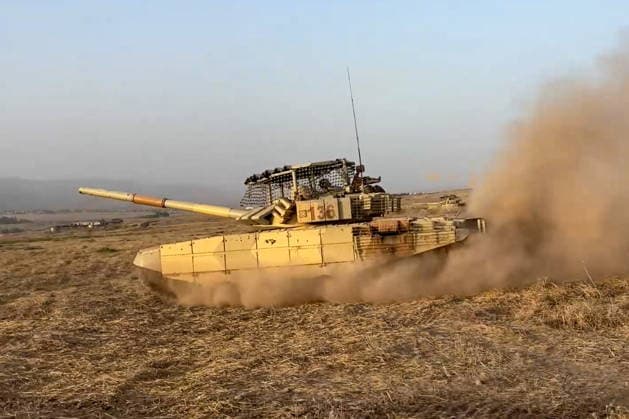 TAJIKISTAN - OCTOBER 3, 2026: Russian tank crews destroy a simulated enemy during the Tsentr Centre 2026 military exercise held at the Lyaur training ground. Video screen grab. Best quality available. Russian Defence Ministry TASS  98708966