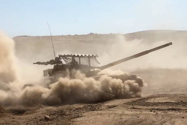 TAJIKISTAN - OCTOBER 3, 2026: Russian tank crews destroy a simulated enemy during the Tsentr Centre 2026 military exercise held at the Lyaur training ground. Video screen grab. Best quality available. Russian Defence Ministry TASS  98708974