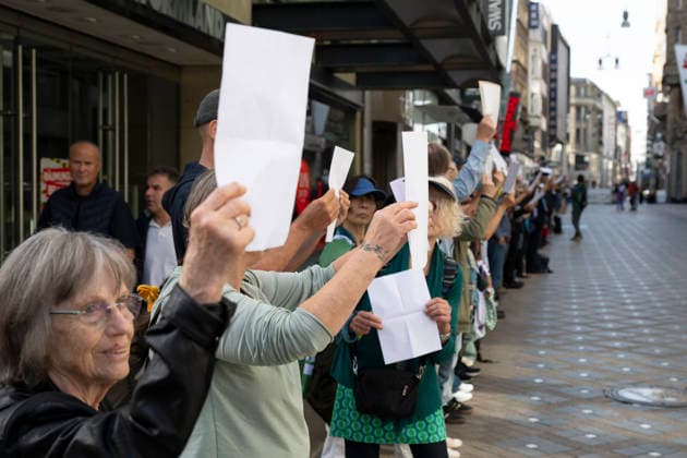 October 3, 2026 Press event: Es brennt initiative—human chain in Dortmund, Hansaplatz; participants on Westenhellweg hold up white paper; Dortmund, Hansaplatz and Westenhellweg, North Rhine-Westphalia, Germany