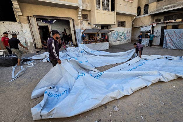 Palestinian Tailor Repairs Tent Covers for Displaced Families in Khan Younis Palestinian tailor Shaaban al-Tabash repairs and assembles tarpaulins and plastic sheets using rudimentary methods to reinforce the tents of displaced Palestinians and protect them from cold weather and rain in Khan Younis, in the southern Gaza Strip, on October 4, 2026. As winter approaches, shortages of protective supplies and the deterioration of many tents after nearly three years of war are worsening living conditions, while al-Tabash uses available materials to extend the life of shelters that have become the last refuge for thousands of displaced people. Photo by Tariq Mohammad APA Images Khan Yunis Gaza Strip Palestinian Territory 041026_Khan_Yunis_TM_01( Copyright: xapaimagesxTariqxMohammad xapaimagesx