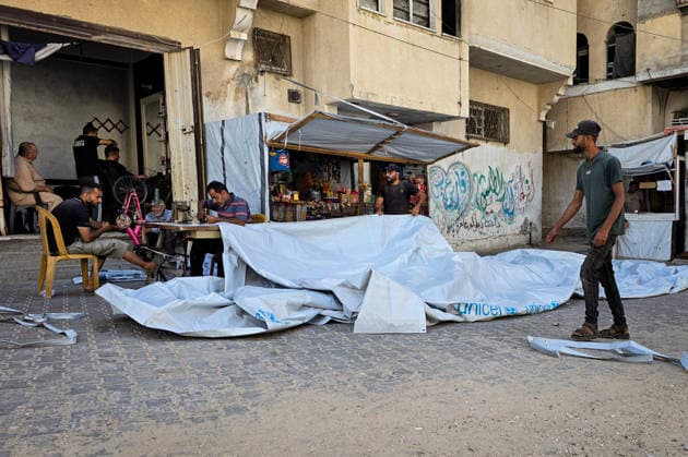 Palestinian Tailor Repairs Tent Covers for Displaced Families in Khan Younis Palestinian tailor Shaaban al-Tabash repairs and assembles tarpaulins and plastic sheets using rudimentary methods to reinforce the tents of displaced Palestinians and protect them from cold weather and rain in Khan Younis, in the southern Gaza Strip, on October 4, 2026. As winter approaches, shortages of protective supplies and the deterioration of many tents after nearly three years of war are worsening living conditions, while al-Tabash uses available materials to extend the life of shelters that have become the last refuge for thousands of displaced people. Photo by Tariq Mohammad APA Images Khan Yunis Gaza Strip Palestinian Territory 041026_Khan_Yunis_TM_01( Copyright: xapaimagesxTariqxMohammad xapaimagesx