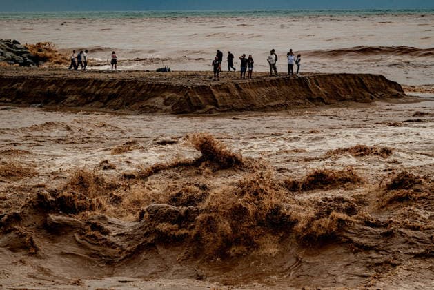 News Bilder des Tages October 4, 2026, Sant Adria Del Besos, Barcelona, Spain: People stays at the mouth of the Besos River, north of Barcelona, swollen and laden with sediment after a night of torrential rain across Catalonia. The storm brought exceptional rainfall to the Barcelona metropolitan area, with more than 200 litres per square metre recorded in parts of the region. The Besos rose sharply overnight, prompting authorities to warn of an imminent risk of flooding. Sant Adria Del Besos Spain  - ZUMAb137 20261004_fap_b137_006 Copyright: xJordixBoixareux