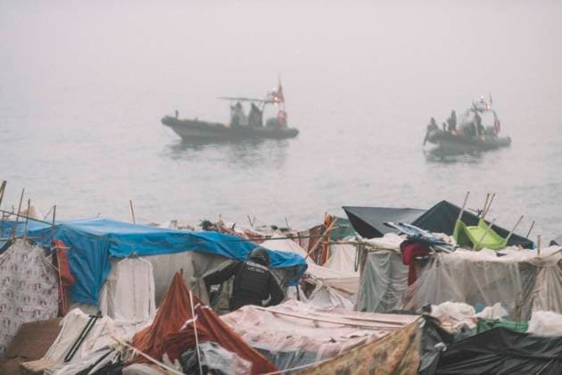 October 4, 2026, Ceuta, Ceuta, Spain: Boats patrol the sea in the fog off the makeshift migrant camp on El Trampolin beach in Ceuta during the eviction. Spanish National Police began evicting the makeshift camp on El Trampolin beach in Ceuta on October 4, where more than 3,000 migrants, most of them young Moroccan men, were living. Dozens of police vans, armoured vehicles of the Police Intervention Units (UIP), drones and boats took part in the operation. People were taken by bus to the temporary centre at the Tarajal border to be identified, and the authorities plan to clear the beach in phases before October 15. The camp grew after a mass arrival at the end of July 2026 set off a migration and political crisis. Ceuta Spain - ZUMAs392 20261004_zip_s392_005 Copyright: xFabianxSuspensivox