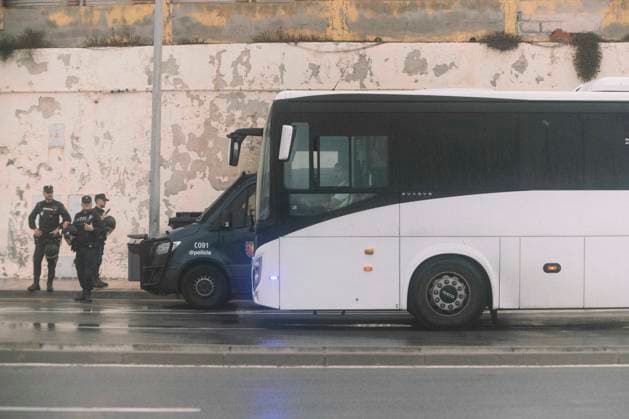 October 4, 2026, Ceuta, Ceuta, Spain: Police officers stand next to a bus by a peeling wall near El Trampolin beach in Ceuta during the eviction of the makeshift migrant camp. Spanish National Police began evicting the makeshift camp on El Trampolin beach in Ceuta on October 4, where more than 3,000 migrants, most of them young Moroccan men, were living. Dozens of police vans, armoured vehicles of the Police Intervention Units (UIP), drones and boats took part in the operation. People were taken by bus to the temporary centre at the Tarajal border to be identified, and the authorities plan to clear the beach in phases before October 15. The camp grew after a mass arrival at the end of July 2026 set off a migration and political crisis. Ceu - ZUMAs392 20261004_zip_s392_021 Copyright: xFabianxSuspensivox