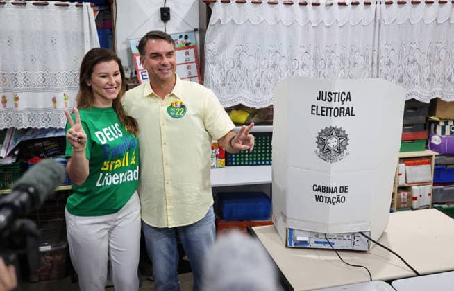 (261004) -- BRASILIA, Oct. 4, 2026 -- Flavio Bolsonaro (R), presidential candidate of Brazil s Liberal Party, poses for photos with his wife after casting his ballot at a polling station in Rio de Janeiro, Brazil, Oct. 4, 2026. Voting in the first round of Brazil s 2026 presidential election officially began at 8 a.m. (1100 GMT) on Sunday, with polling stations across the country scheduled to close at 5 p.m. (0800 GMT). Initial results are expected to be announced within a few hours after the polls close. ) BRAZIL-PRESIDENTIAL ELECTION-VOTING JinxHaoyuan 