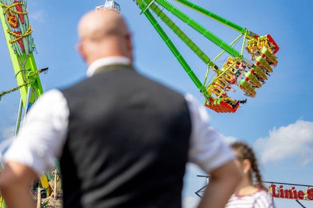 Oktoberfest 2026 in Munich, October 4, 2026: A man in traditional dress looks at a ride at Oktoberfest. The 191st Oktoberfest took place from September 19 to October 4, 2026, at the Theresienwiese. The Munich Oktoberfest is one of the world’s largest folk festivals and attracts millions of visitors from Germany and abroad every year. Munich, Theresien