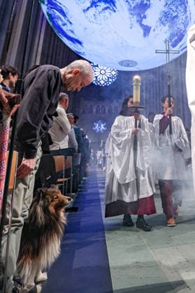 October 4, 2026, New York, New York, United States: A dog looks towards the incense as Cathedral clergy process beneath Gaia, the monumental illuminated Earth installation by British artist LUKE JERRAM, during the Blessing of the Earth and Animals at the Cathedral of St. John the Divine in New York. New York United States - ZUMAo116 20261004_znp_o116_025 Copyright: xBiancaxOterox