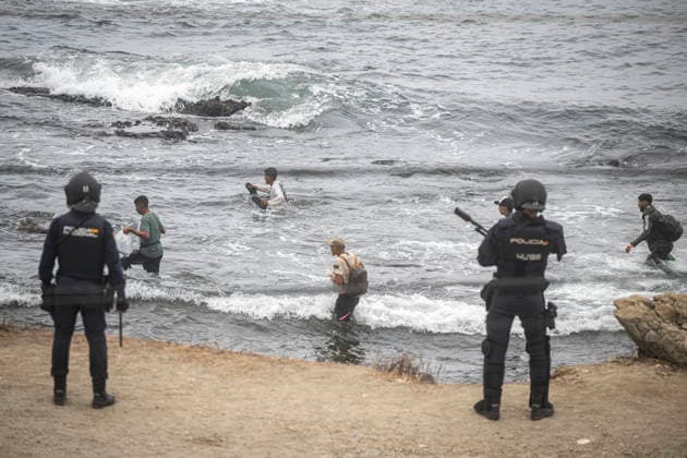 The migrants evicted from El Trampolín are divided between those who return to Morocco and those who prefer to register. National Police officers intervene during the eviction of the group of migrants gathered on El Trampolín Beach on October 4, 2026, in Ceuta, Spain. The National Police escort buses full of migrants evicted from El Trampolín Beach toward the Tarajal border area, where some choose to stay at the Temporary Care Center for Foreigners (CATE) in order to be registered and subsequently accommodated, while others prefer to return to Morocco on foot and voluntarily. OCTOBER 4, 2026 MIGRATION CRISIS Ceuta, Spain  Copyright: xMarcosxMorenox 7820578