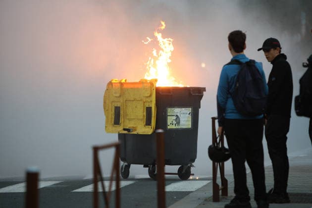 October 5, 2026, Anglet, Nouvelle Aquitaine, France: Youths look on as a waste container burns during a protest by high school students against the government outside the Cantau high school in Anglet, southwestern France, on October 5, 2026. Students have been blocking schools across France since September 21 to demand more teachers, smaller classes and better school buildings. Cantau was closed by authorities after clashes in recent days. Anglet France  - ZUMAb298 20261005_zsp_b298_009 Copyright: xJulesxBuonx