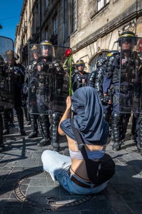 October 6, 2026, Bordeaux, Nouvelle-Aquitaine, France: Seated on the ground in front of mobile gendarmes, a young high school student offers them a rose during the demonstration in Bordeaux on October 6, 2026. Bordeaux France  - ZUMAh207 20261006_zip_h207_001 Copyright: xFabricexHebertx