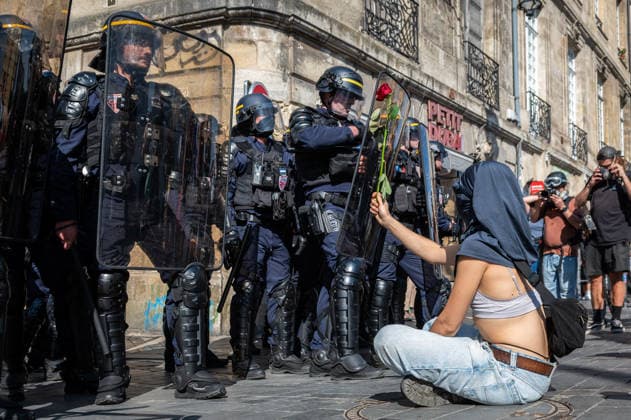 October 6, 2026, Bordeaux, Nouvelle-Aquitaine, France: Seated on the ground in front of mobile gendarmes, a young high school student offers them a rose during the demonstration in Bordeaux. Bordeaux France - ZUMAh207 20261006_zip_h207_002 Copyright: xFabricexHebertx
