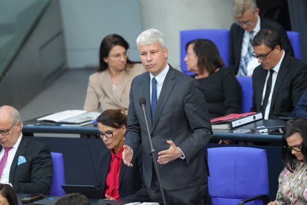 German Bundestag, 98th Plenary Session: Transportation Minister Steffen Bilger answers questions from members of parliament with expressive facial expressions and gestures from his seat on the government bench during the questioning of the federal government at the 98th session of the German Bundestag in Berlin, October 7, 2026, Berlin, Berlin, Germany
