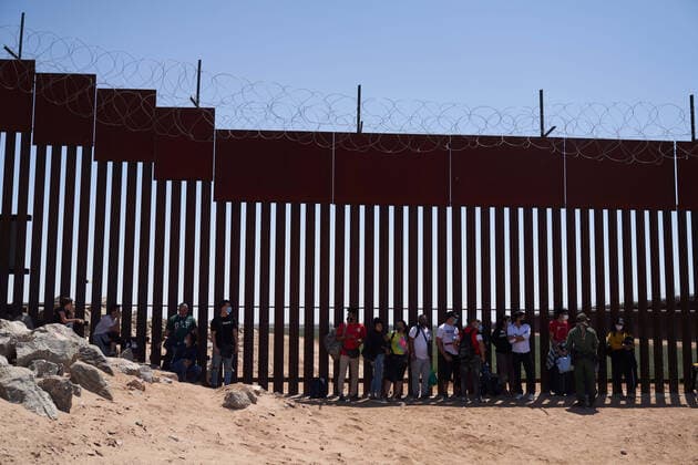 U.S., migrants surrender to U.S. Border Patrol in Yuma at border wall with Mexico