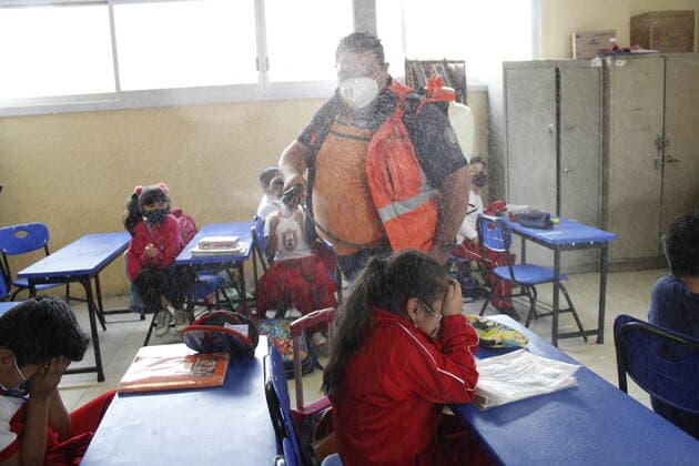 Mexico, use of disinfectant spray in a primary school classroom in Mexico City.