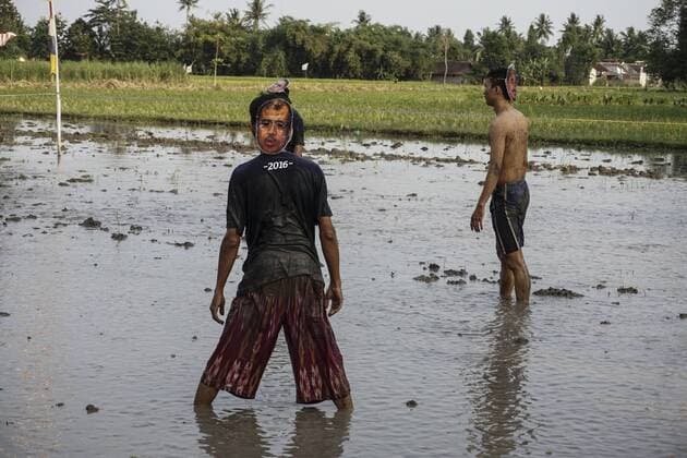Indonesia: Young people play mud football on Independence Day