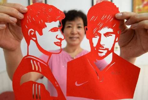 Artist Feng Shiping makes paper cuts of football stars