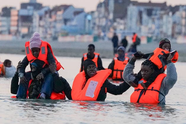 Dunkirk, migrants with children wait for rubber dinghy to cross the English Channel