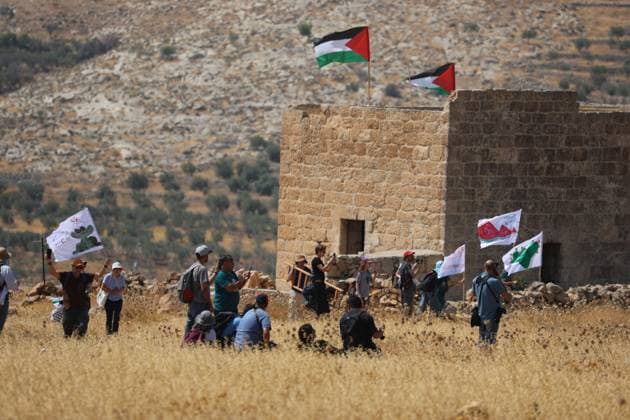 Middle East conflict, West Bank, activists remove Israeli flags from a Palestinian house in Beit Sahour