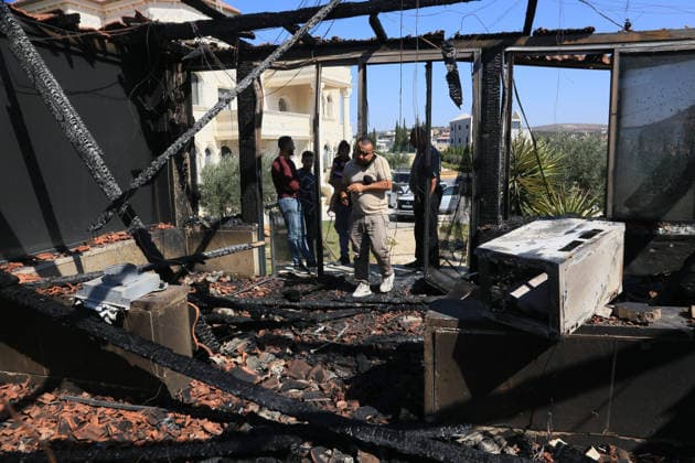 Middle East conflict, West Bank: Palestinians assess fire damage following an attack near Nablus