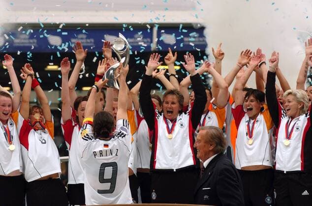 Birgit Prinz reckt die Trophäe für den Gewinn der Europameisterschaft 2005 in die Luft, v.re. jubeln Co Trainerin Silvia Neid, Ariane Hingst und Bundestrainerin Tina Theune Meyer (alle Deutschland) Fußball EM Damen Europameisterschaft 2005, Frauen, Frauenfußball, Finale, Endspiel, Länderspiel, Feier, feiern Gruppe Trainer, Coach, Assistent, Assistenztrainer Blackburn Freude, Begeisterung,