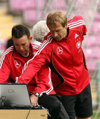 Trainingsberater Craig Friedman (USA Athlete Performance, li.) zeigt Bundestrainer Jürgen Klinsmann (Deutschland) die Leistungsergebnisse auf seinem Laptop Fußball WM Herren Nationalmannschaft 2006, Vorbereitung, Training Gruppe Trainer, Coach, Nationalcoach, Nationaltrainer, Genf, Analyse, Trainingsanalyse, Computeranalayse
