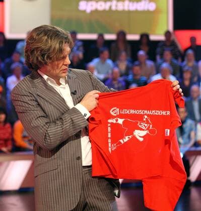 ZDF Moderator Michael Steinbrecher präsentiert im Aktuellen Sportstudio ein Tshirt mit der Aufschrift Lederhosenauszieher und einem Konterfei von Branko Jelic (Cottbus) der gegen die Bayern beide Treffer zum 2:0 Sieg der Cottbuser erzielte Fußball 1. BL Herren Das Aktuelle Sportstudio 2008, Fernsehen, TV, Medien, ZDF, Sendung, Fernsehsendung, Vdig Einzelbild Mainz Fußball 1. BL Herren Das Aktuelle Sportstudio 2008, Fernsehen, TV, Medien, ZDF, Sendung, Fernsehsendung, Vdig Einzelbild Mainz