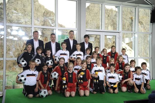 Kinder repräsentieren die Spieler während der Bekanntgabe des EM Kaders 2008 auf der Zugspitze, dahinter v.li.: Torwarttrainer Andreas Köpke, Co Trainer Hans Dieter Flick, Teammanager Oliver Bierhoff, Bundestrainer Joachim Löw (alle Deutschland) Fußball EM Herren Vorschau Euro 2008, Nationalmannschaft, Pressekonferenz, Pressetermin, Vorstellung, DFB, Totale Garmisch Partenkirchen, Zugspitze Hansi Fußball EM Herren Vorschau Euro 2008, Nationalmannschaft, Pressekonferenz, Pressetermin, Vorstellung, DFB, Totale Garmisch Partenkirchen, Zugspitze Hansi