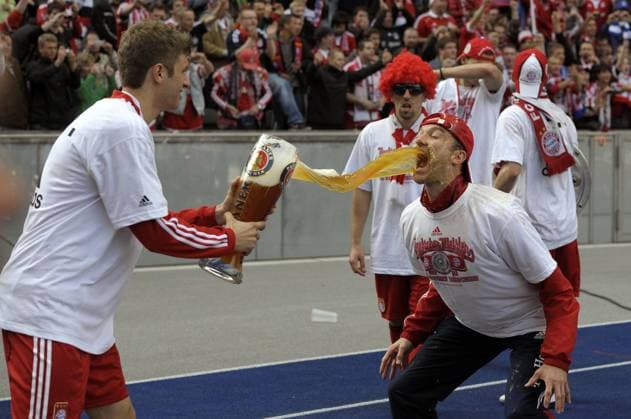 08.05.2010, Fussball 1.Liga, 34.Spieltag: FC Bayern München, im Berliner Olympiastadion, Die Bayern feiern den Gewinn der deutschen Meisterschaft 2009 2010. Thomas Müller (li) schüttet Fitnesstrainer Thomas Wilhelmi (beide Bayern) das Bier direkt in den Mund. o0 Jubel, Freude, Objekte, Glas, Bierglas, Bier, Weißbier, Alkohol