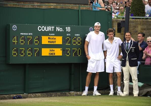 Gewinner John Isner (USA, L) und Nicolas Mahut (Frankreich, M) mit Stuhlschiedsrichter Mohamed Lajani (SWE) nach dem Spiel vor der Anzeigetafel - Der letzte Satz im längsten Tennismatch aller Zeiten endet 70:68 für John Isner, ein paar Rekordfakten zum Spiel: Spielzeit 11 Stunden und fünf Minuten an insgesamt 3 Tagen, 193 Asse insgesamt, 183 Spiele o0 Anzeigetafel, Anzeige, Tafel, Stadionanzeige Ergebnis, Resultat, Spielstand Referee