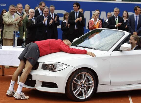 BMW Open 2011,250 ATP Tennis Herren World Tour, Tennis Turnier, International Series,Iphitos Tennis Club, Sandplatz,Finale,Siegerehrung,Praesentation, Einzel,Sieger Nikolay Davydenko (RUS) legt sich auf die Kuehlerhaube von seinem gewonnenen Auto,lustig,Humor, o0 München Objekte Sponsor, Werbepartner, Werbung, Wirtschaft, PKW Freude