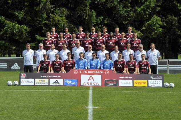 Mannschaft des 1. FC Nürnberg (v lks hintere Reihe - Albert Bunjaku, Daniel Didavi, Markus Feulner, Javier Pinola, Marvin Plattenhardt, Mike Frantz, Manuel Zeitz; 2. Reihe von hinten - Alexander Esswein, Timothy Chandler, Dominic Maroh, Rubin Okotie, Per Nilsson, Wilson Kamavuaka, Timmy Simons, Christian Eigler; 2. Reihe von vorne - Trainer Dieter Hecking, CoTrainer Armin Reutershahn, CoTrainer Dirk Bremser, Athletik-Rehatrainer Andreas Beck, Torwarttrainer Adam Matysek, Dr. Matthias Brem, Physio Günter Jonczyk, Physio Sven Brechetsbauer, Physio Sascha Rurainski, Zeugwart Günter Chico Vogt, Busfahrer Udo Rauh; Vordere Reihe - Julian Wießmeier, Markus Mendler, Philipp Wollscheid, Alexander Stephan, Raphael Schäfer, Patrick Rakovsky, Jens Hegeler, Robert Mak und Juri Judt) bei der Vorstellung zur Saison 2011 2012 in Nürnberg; 05 07 2011 -