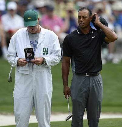 April 10, 2015 - Augusta, GA, USA - Tiger Woods, right, glances over at the yardage book his caddie, Joe LaCava, left, holds on the 16th green during second round action of the Masters at Augusta National Golf Club on Friday, April 10, 2015 in Augusta, Ga. Woods finished the round at -2. Masters day 2 - ZUMAm67_